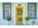 Bright yellow front door with a wreath flanked by blue windows at 332 N Congdon St., Georgetown, SC 29440