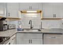 Modern kitchen sink and granite countertop with white cabinets at 6000 N Ocean Blvd. # 214, North Myrtle Beach, SC 29582
