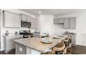 Modern kitchen with gray cabinets, granite countertops, and an island at 898 Farmers Passage Loop, Loris, SC 29569