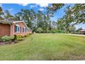 Landscaped side yard with grassy area and mature trees at 3503 Pinewood Dr., Loris, SC 29569