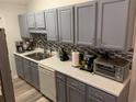 Kitchen boasts gray cabinets, mosaic backsplash, and modern appliances at 706 Wintercreeper Dr., Longs, SC 29568