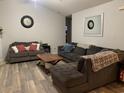 Spacious living room with gray sectional sofa and wood-look floors at 706 Wintercreeper Dr., Longs, SC 29568