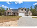 Brick and beige two-story house with a three-car garage and landscaped yard at 3329 Hughes Gasque Rd., Aynor, SC 29511