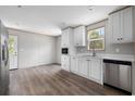 Modern kitchen featuring white cabinets, stainless steel appliances, and wood-look flooring at 3811 Wayside Rd., Conway, SC 29527