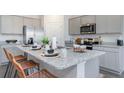 Modern kitchen with gray cabinets, granite countertops, and an island with seating at 724 Wallace Dr., Little River, SC 29566