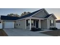 Gray house with a dark gray roof, white garage door, and landscaped yard at 106 Ivy Creek Ct., Conway, SC 29527