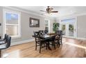 Bright dining room featuring a large table, hardwood floors, and access to a deck at 1050 Waccamaw Dr., Garden City Beach, SC 29576