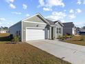House exterior showcasing a green facade, white garage door, and well-maintained lawn at 1143 Sennema Circle, Myrtle Beach, SC 29588