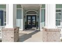 Elegant front entry with double doors, flanked by columns and planters at 5987 Bolsena Place, Myrtle Beach, SC 29577