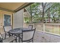 Deck with round metal table and chairs, overlooking trees and other condos at 101 Westhill Circle # 5-C, Myrtle Beach, SC 29572