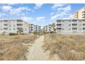 Beach access pathway with dunes and oceanfront building in background at 2405 S Ocean Blvd. # 207, North Myrtle Beach, SC 29582