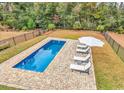 Backyard oasis featuring a rectangular in-ground pool, lounge chairs, and a white umbrella at 28 Pinnacle Dr., Murrells Inlet, SC 29576