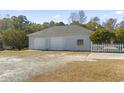 Two-car detached garage with a gravel driveway and white picket fence at 601 Saint Johns Circle, Longs, SC 29568