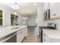 Open concept kitchen with island, stainless steel appliances, and white cabinetry at 7035 Shooting Star Way, Myrtle Beach, SC 29579