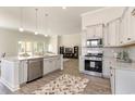 Open concept kitchen with island, stainless steel appliances, and hardwood floors at 7060 Shooting Star Way, Myrtle Beach, SC 29579