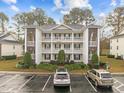 Front view of a three-story condo building with parking at 1238 River Oak Dr. # D, Myrtle Beach, SC 29579