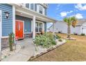 Inviting front porch with orange door and relaxing seating area at 1362 Tessera Way, Myrtle Beach, SC 29579