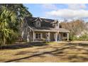 Gray house with a covered porch, and American flag at 3940 Loblolly Ave., Little River, SC 29566