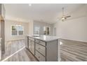 Open concept kitchen with island, gray cabinets, and hardwood floors at 426 Lifestyle Court, Surfside Beach, SC 29575