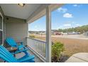 Front porch with two blue chairs and view of the neighborhood at 480 Oakham Dr., Conway, SC 29527