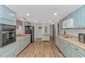 Light teal kitchen with stainless steel appliances and wood-look floors at 6001-Mh81 S Kings Hwy., Myrtle Beach, SC 29575