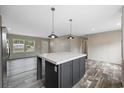 Modern kitchen with a large island, dark cabinets, and wood-look flooring at 133 Melanie Brooke Ln., Conway, SC 29527