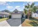 Inviting home with a two-car garage, paved driveway, and lush landscaping at 239 Coachman Dr., Pawleys Island, SC 29585