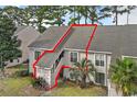 Tan two-story condo building with grey roof, visible stairs, and palm trees at 4486 Little River Inn Ln. # 2105, Little River, SC 29566