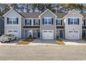 Three-unit townhome building, gray siding, two-car garages, and well-manicured landscaping at 608 Montenegro Way # E, Myrtle Beach, SC 29579