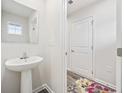 Small powder room with pedestal sink, mirror, and access to hallway at 608 Montenegro Way # E, Myrtle Beach, SC 29579