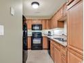 Kitchen with wood cabinets and black appliances at 8121 Amalfi Pl. # 5-103, Myrtle Beach, SC 29572