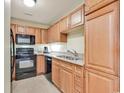 Kitchen with light wood cabinets, black appliances, and granite countertops at 8121 Amalfi Pl. # 5-103, Myrtle Beach, SC 29572