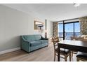 Living room featuring a teal sofa, dining table, and ocean view at 1501 S Ocean Blvd. # 1243, Myrtle Beach, SC 29577