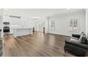 Open-concept living area with wood-look flooring, a black couch, and a view of the kitchen at 308 Golan Circle # C, Myrtle Beach, SC 29579