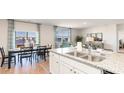 Open-concept kitchen and dining area with granite countertops, white cabinets, and sliding glass doors leading to the water at 1179 Maxwell Dr., Little River, SC 29566