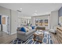 Open-concept living area with gray sofa, large windows overlooking green space, and view of kitchen at 3413 Cove Side Ct., North Myrtle Beach, SC 29582