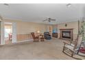 Cozy living room with fireplace, rocking chairs, and access to the dining area at 5080 Forest Dr., Loris, SC 29569