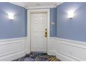 White front door of condo with blue walls, white trim, and patterned carpet at 9994 Beach Club Dr. # 1604, Myrtle Beach, SC 29572