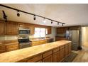 Kitchen with wood cabinets, stainless steel appliances, and track lighting at 3734 Highway 554, Loris, SC 29569