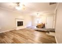 Spacious living room with wood-look floors, fireplace, and ceiling fan at 3734 Highway 554, Loris, SC 29569