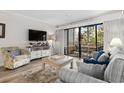 Welcoming living room with comfortable seating, sliding glass door to balcony, and coastal decor at 415 Ocean Creek Dr. # 2236, Myrtle Beach, SC 29572