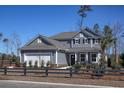 Gray two-story house with white garage door and a black fence at 1320 Winding Creek Way, Myrtle Beach, SC 29588