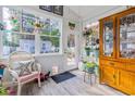 Bright sunroom with stained glass, wood flooring, and built-in cabinets at 405 Cypress Springs Way, Little River, SC 29566