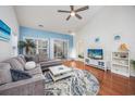 Spacious living room with hardwood floors, sectional sofa, and large TV at 5804 Longwood Dr. # 301, Murrells Inlet, SC 29576