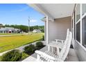 Quaint front porch with two white rocking chairs and a view of the neighborhood at 612 Pine Oaks Farm Rd., Aynor, SC 29511