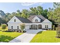 Two-story home with gray siding, stone accents, and a three-car garage at 1017 Muscovy Pl., Conway, SC 29526