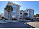 Brick condo building with arched windows and palm trees in front at 4717 Wild Iris Dr. # 29-303, Myrtle Beach, SC 29577