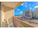 Balcony view of the ocean and adjacent building, with two chairs at 202 75Th Ave N # 5704/5705, Myrtle Beach, SC 29572