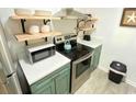 Updated kitchen with stainless steel appliances and light teal cabinets at 202 75Th Ave N # 5704/5705, Myrtle Beach, SC 29572