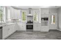 Modern kitchen with white cabinets, stainless steel appliances, and a tile backsplash at 5575 Dinkler Ave., Loris, SC 29569